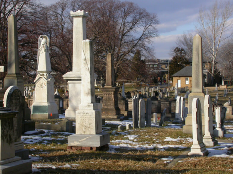 Figura 25. Congressional Cemetery, Washington, DC. Tumba del Dr. George B. McKnight y su familia cercana. Primer obelisco al frente y a la izquierda del centro de la fotografía de arriba. El detalle de la base esta ampliado en la foto de abajo y muestra la información vital del Dr. McKnight, ahora algo borrosa.