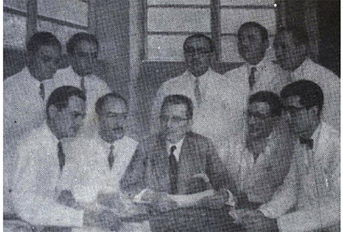 Fig 13: La Cátedra de Cirugìa IV. Óleo del pintor Fantúzzi. 1957 Fermín Mendoza, Ricardo Baquero, Pedro Blanco Gásperi, Martín Valdivieso y Alberto París. De pie Roque Mazziota, Ramón Téllez, Luis Barrios, Juan Luis Heredia y Jacobo Vásquez. Fuente: Francisco Plaza I. Hospital Universitario de Caracas. Recuento Histórico en su Trigésimo Aniversario. Tomo II. Imprenta Universitaria UCV. Caracas, 1986