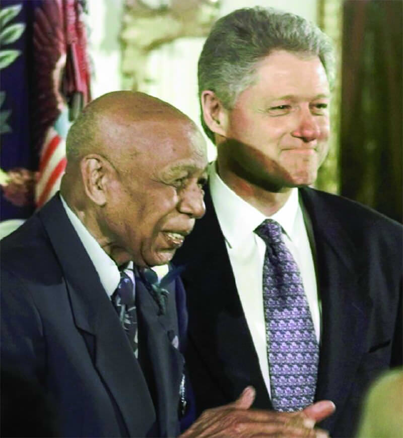 Fig 4. Herman Shaw, sobreviviente del EST, junto al presidente Clinton en la Casa Blanca. Remembering Tuskegee and making amends, 1997. [Greg Gibson/AP Photo]. In: Peter J Waugh. Getting ethics into practice. Comparing Alder Hey with Tuskegee is not helpful. BMJ 2004